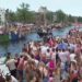 Revellers line Amsterdam canal to watch the annual Pride boat parade