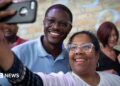 David Crowley poses for a selfie alongside a supporter while campaigning to be the Democratic candidate for Wisconsin governor