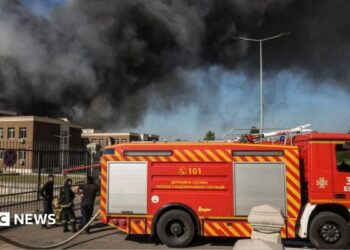 Firefighters work at the site of a Russian drone strike as smoke rises, amid Russia's attack on Ukraine, in Kyiv region, Ukraine