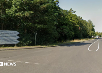 A sign leading to Mechernich military base, with the entry checkpoint visible in the distance.