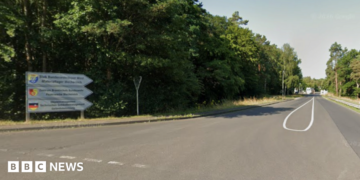 A sign leading to Mechernich military base, with the entry checkpoint visible in the distance.