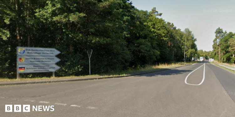 A sign leading to Mechernich military base, with the entry checkpoint visible in the distance.