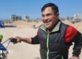Ahmed al Madhoun smiles as he holds his bike.