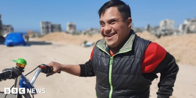 Ahmed al Madhoun smiles as he holds his bike.
