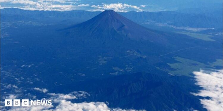Mount Fuji is pictured from the skies with a ring of white cloud bordering the frame of the image