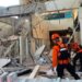 Emergency workers look through the rubble at Lauren Say port in Maumere