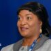Jewel Howard-Taylor  wears a blue lanyard and grey jacket, gold earring at an economic forum in Poland, 2021. She has shiny black hair.