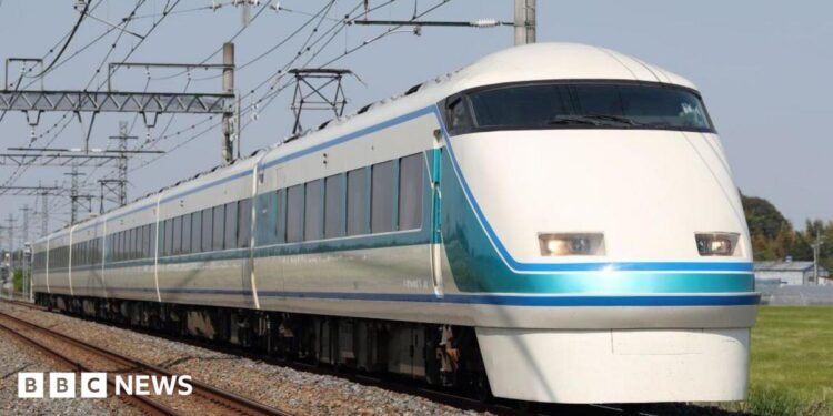 A train travelling on tracks across a field