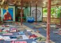 Mats and rugs can be seen on the floor of an open-walled space for meditation