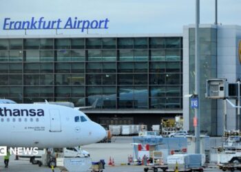 A view of a taxiing area at Frankfurt Airport. A Lufthansa plane sits on the tarmac.