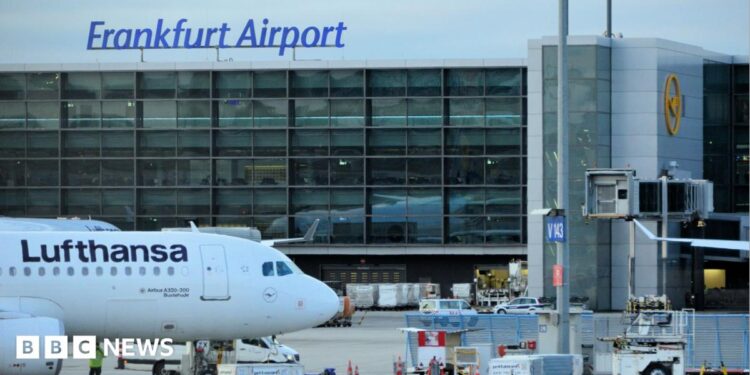 A view of a taxiing area at Frankfurt Airport. A Lufthansa plane sits on the tarmac.
