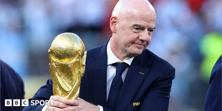 Gianni Infantino with his hands around the men's World Cup trophy
