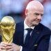 Gianni Infantino with his hands around the men's World Cup trophy