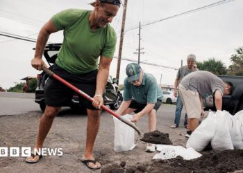 Captain Hook, Hawaii residents prepare stuff bags with sand in preparation of Tropical Storm Lala on Friday