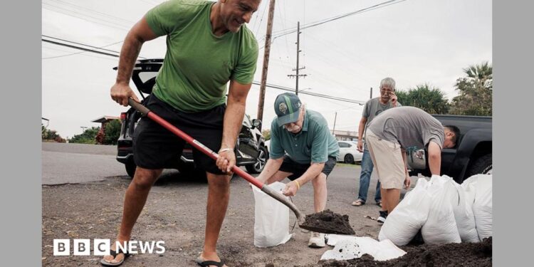 Captain Hook, Hawaii residents prepare stuff bags with sand in preparation of Tropical Storm Lala on Friday