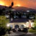 Flames burning in hills above a home