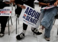 Supporters of U.S. Senate Democratic candidate Abdul El-Sayed hold campaign signs during a rally in Dearborn