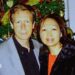 A police handout of Peter Chadwick and his wife Quee Choo Chadwick. They are shoulder to shoulder and looking at the camera, stood in front of a Christmas tree. He is in a grey suit jacket and black shirt, she is wearing a red top and black jacket.
