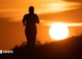 A woman jogs along a path as the sun rises in Frankfurt am Main, Germany, 09 July 2026.