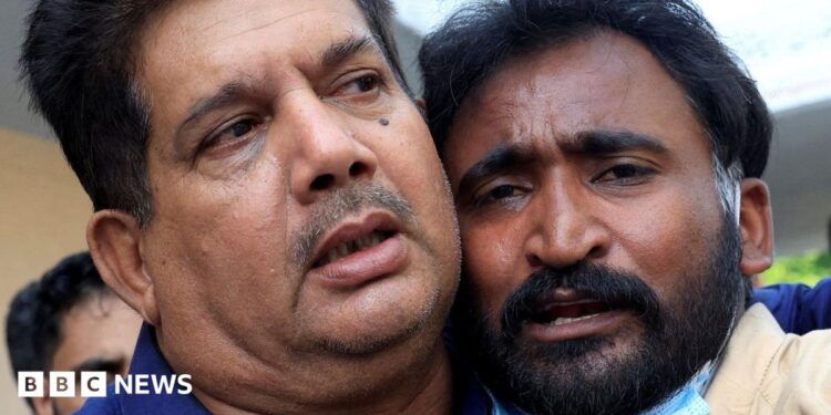 Samiullah, the father of a newborn who was killed in the PIMS hospital blaze, is comforted.