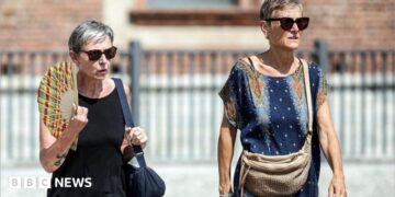 People drink water and use hand fans to protect themselves from the sun in Naples, southern Italy. Photo: 1 August 2026