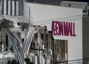 A damaged building with the words Aeon Mall on its side