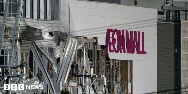 A damaged building with the words Aeon Mall on its side