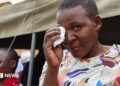 A female survivor uses a tissue to wipe tears from her eyes during a memorial service held for victims of the capsized ferry at Nyamhunga Stadium in Kariba - 13 August 2026