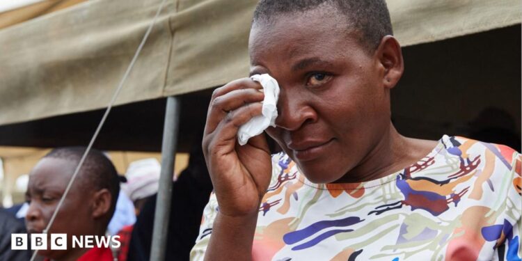 A female survivor uses a tissue to wipe tears from her eyes during a memorial service held for victims of the capsized ferry at Nyamhunga Stadium in Kariba - 13 August 2026