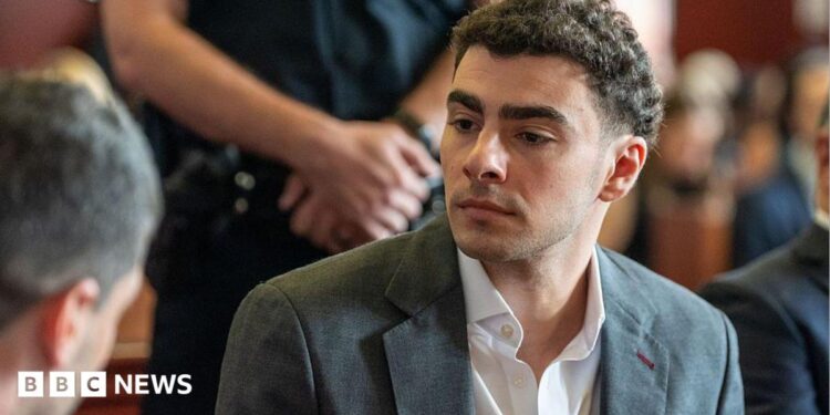 Luigi Mangione wears a charcoal grey suit as he sits in court for a recent state hearing.
