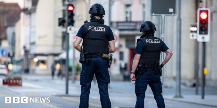 Police officers patroll a street in downtown Aarau