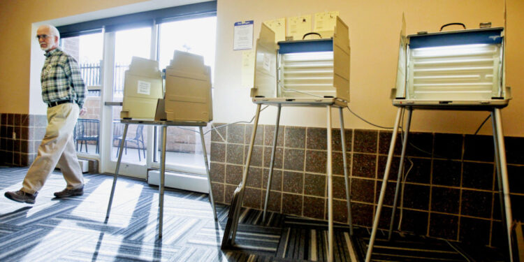 St. Louis County Election Official Chuck Wentworth walks around the empty polling room at The Heights in St. Louis