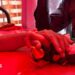 Person holds hand of victim on hospital bed