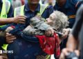 Rescuers transport an elderly woman rescued from flooded area