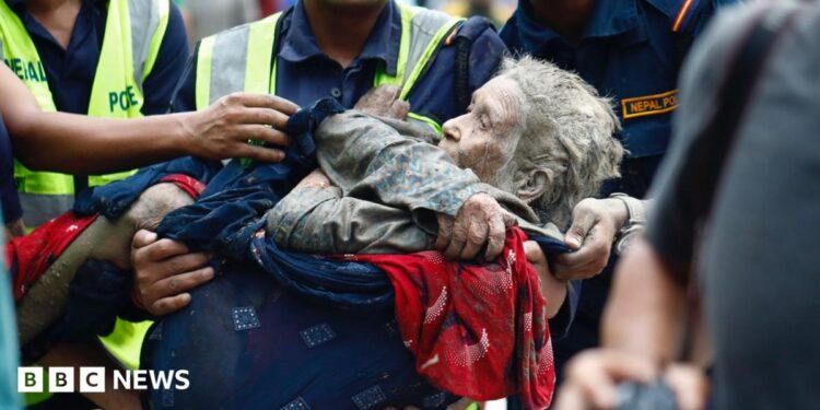 Rescuers transport an elderly woman rescued from flooded area
