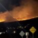Picture taken at night showing fires burning on hill, plumes of white smoke covering the skies