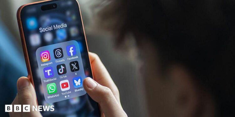A stock image showing looking at the social media application menu, which includes apps for Instagram, Facebook and TikTok, on his smartphone.