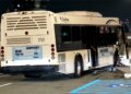 shuttle bus rests against a concrete barrier after the crash