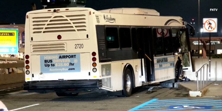 shuttle bus rests against a concrete barrier after the crash