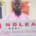 Afolabi Kazeem Micheal holds up a NDLEA sign with his name and age after his arrest in Lagos