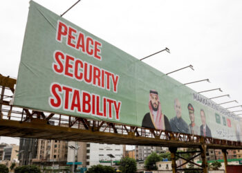 Billboard displays leaders following the signing of the Makkah Joint Defence Agreement, in Karachi