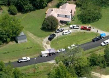 An aerial view of a house with cars parked in front