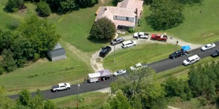 An aerial view of a house with cars parked in front