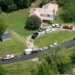 An aerial view of a house with cars parked in front