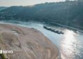 An aerial view as a cargo ship passes a huge exposed sandbar on the Rhine River