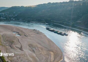 An aerial view as a cargo ship passes a huge exposed sandbar on the Rhine River
