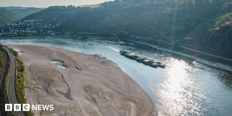An aerial view as a cargo ship passes a huge exposed sandbar on the Rhine River