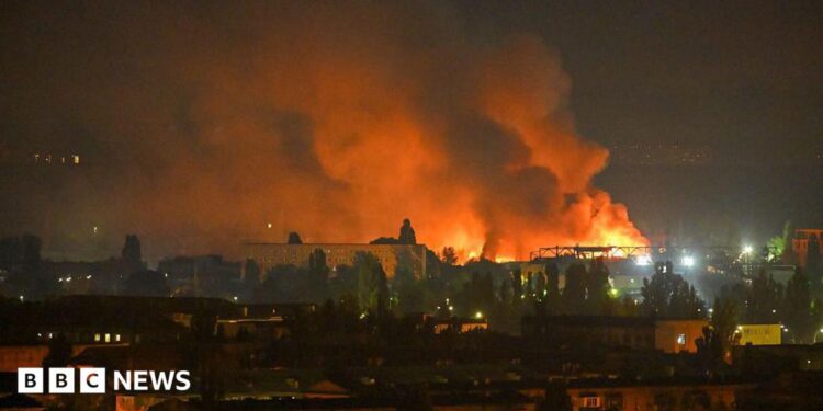 A fire breaks out following massive Russian ballistic missile strikes in the Ukrainian capital of Kyiv, with orange and black plumes of smoke expanding across the night sky.