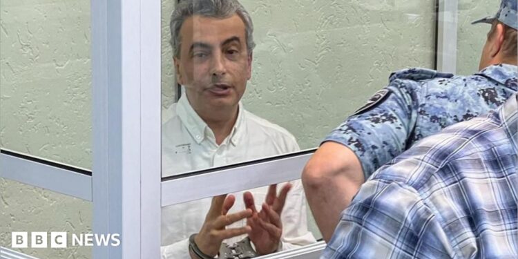 Lev Shlosberg (left, in handcuffs) attends a court hearing in Pskov, western Russia. Photo: 17 September 2026.