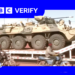 A Russian military vehicle being transported through the Malian capaitl, Bamako. Men on motorcycles are riding alongside it.